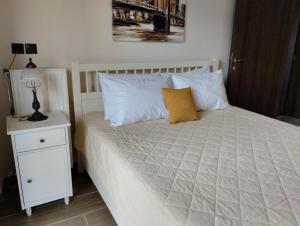 约阿尼纳XΡΗΣΤΟΣ house的一张带白色枕头的床和一个带灯的床头柜