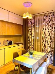 阿拉木图жк vostochkakz的厨房配有桌椅和微波炉。