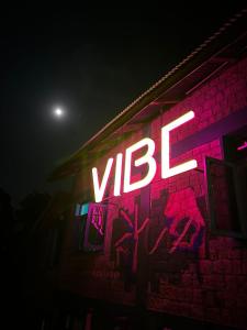 达兰萨拉Vibe Hostel的涂鸦建筑一侧的 ⁇ 虹灯标志