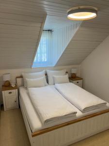 博德森特克Bella Mura Nature Apartment Lipa 97的一张带白色床单和枕头的床