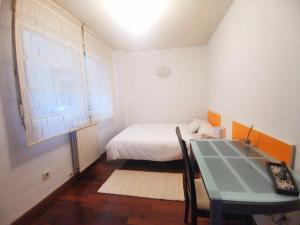 马里亚诺Habitación cerca del aeropuerto的一间小卧室,配有一张床和一张桌子