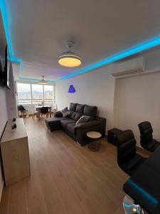 贝尼多姆Hany apartment Tropic mar 18-C的客厅配有黑色沙发和桌子