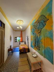 丹吉尔Dar Mora的卧室配有一张床,墙上挂有绘画作品
