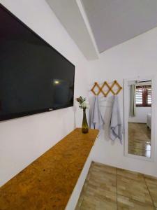 杰里科科拉Na Casa Delas Jeri - com Churrasqueira的客厅配有壁挂式大屏幕平面电视