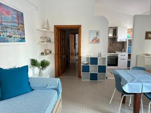 吉诺萨滨海B&B Il Timone - Ginosa Marina的一间带蓝色沙发的客厅和一间厨房