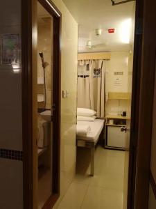 香港景士迪宾馆的小型浴室设有小床和水槽