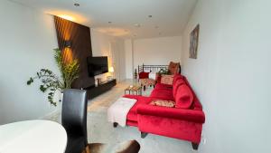 居特斯洛RelaxDays-Apartments的客厅配有红色沙发和电视