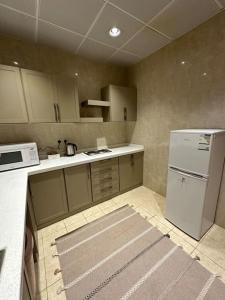 麦地那وحدة سكنية فاخرة 2 Luxury residential unit的厨房配有白色冰箱和炉灶。
