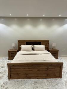 麦地那وحدة سكنية فاخرة 2 Luxury residential unit的一间卧室配有一张带2个床头柜的大型木床
