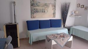 加埃塔Country House Gaeta的客房配有一张带蓝色枕头的床和一张桌子。