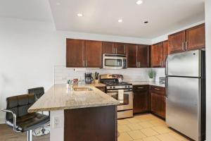 芝加哥Chic & Elite 1BR Apartment in Hyde Park - Shoreland 714的厨房配有木制橱柜和不锈钢冰箱。