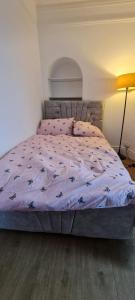 曼彻斯特Scotland Street, Newton Heath的卧室内的一张带紫色棉被的床