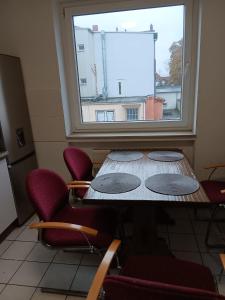汉诺威Othman Appartements Anderter Straße 55g, 1 OG L的窗户客房内的桌椅