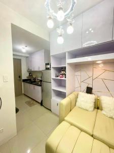 马尼拉Condo Home Near MOA and Airport的一间带黄色沙发的客厅和一间厨房