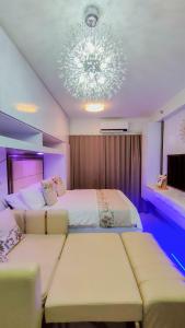 马尼拉Condo Home Near MOA and Airport的一间卧室配有两张床和吊灯。