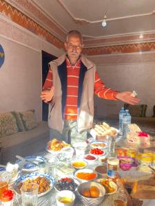 马拉喀什Dar Imoughlad的站在餐桌前,吃着食物的人