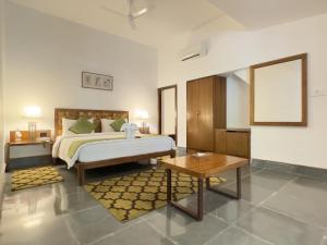 加尔加Saraca Resort & Spa Corbett的一间大卧室,配有一张床铺和一张桌子