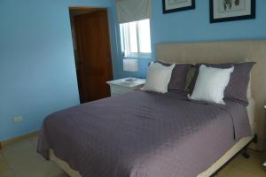 La FragataThe blue lagoon of the Caribbean Sea. Velero 205.Cadaques Caribe的一间卧室配有一张带紫色床单的床和窗户。