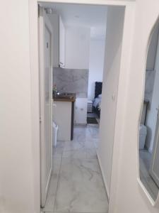 里巴斯卡班亚Apartman Aleksandar 2的走廊设有白色厨房和镜子