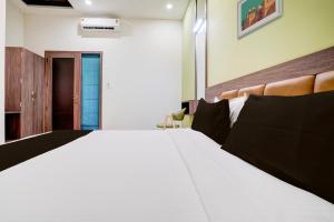 孟买Super Collection O Kalyan West的卧室配有一张带黑色枕头的大型白色床。