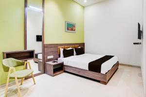 孟买Super Collection O Kalyan West的一间卧室配有一张床和一把椅子
