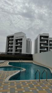 阿吉曼شقة فندقية ALzorah Ajman - الزوراء عجمان的2栋建筑前方设有游泳池