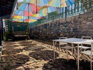 BonfimCasa de Veraneio Villa Lopes的挂在围栏上的桌椅和遮阳伞