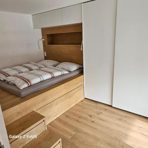圣杰内肖阿泰西诺Sonnenparadies的一间铺有木地板的小卧室,配有一张床