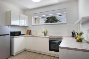 马尔卡纳Sunshine Villa Dvori的厨房配有白色橱柜和窗户。