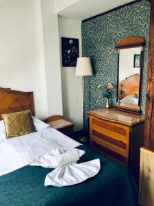 布拉格GEO酒店的一间卧室配有一张床、梳妆台和镜子