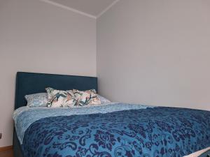 什切青Turkusowa Apartament的一间卧室配有一张带蓝色棉被的床