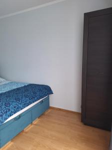 什切青Turkusowa Apartament的一间卧室配有一张蓝色的床和一个衣柜