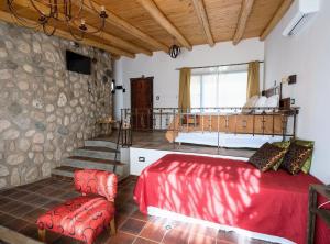 圣哈维尔Tantasiña Cabañas Suites de Montaña的一间带红色床的卧室和一个阳台