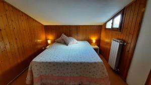 菲利内瓦尔达诺La Mansarda的木制客房内的一间卧室,配有一张床