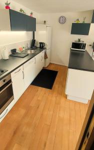 格雷乌莱班Dépendance Spacieux Duplex 50 M2 Classé 3 étoiles sans vis-à-vis的厨房铺有木地板,配有白色橱柜。