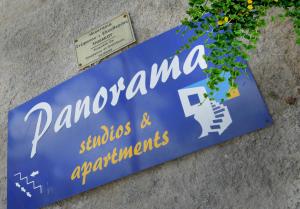 米尔泰Panorama Studios & Apartments的建筑物一侧的蓝色标志