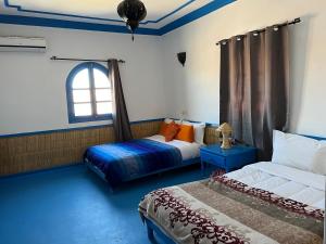 阿伊特本哈杜ETOILE FILANTE D Or的一间卧室设有两张床和窗户。