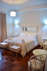 菲乌米奇诺La Magnolia 140的一间卧室配有一张大床、两把椅子和一张桌子