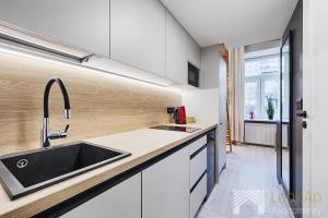 罗兹U Fabrykanta by LookAp的厨房配有白色橱柜和水槽