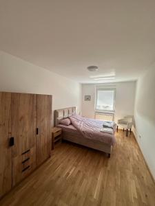 VrbasStan na Dan Vrbas Zeljko的一间卧室配有一张床和一个大型木制橱柜