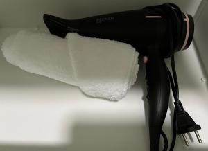 比索达雷加Primeiro Quartel Apartments - 5的黑色吹风机和一卷纸质毛巾
