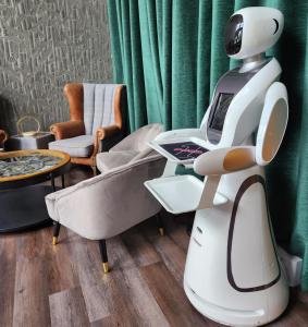考斯Pinnacle Suites的坐在沙发间的一个白色机器人