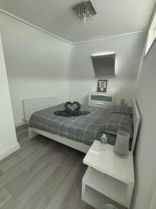 NorwoodModern 3 bed flat near Crystal Palace Stadium with great transport links的一间小卧室,配有一张床和一张桌子