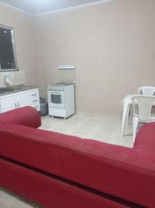 马卡埃Residencial Barbosa - Apto 302的一间带红色沙发的客厅和一间厨房
