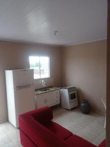 马卡埃Residencial Barbosa - Apto 302的带冰箱和红色沙发的厨房
