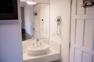 坎布里Alua Pousada的白色的浴室设有水槽和镜子