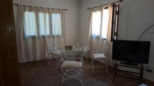 圣卡洛斯La casa Roja的客厅配有桌椅和电视。