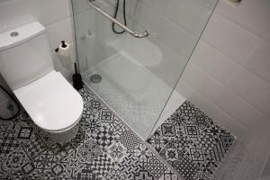 辛特拉Ana's Guesthouse的一间带卫生间和玻璃淋浴间的浴室