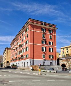 热那亚Appartamento Sofia a Genova的街道边的一座红色大建筑