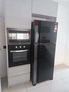 珍南海滩M-Residence的厨房配有黑色冰箱和微波炉。